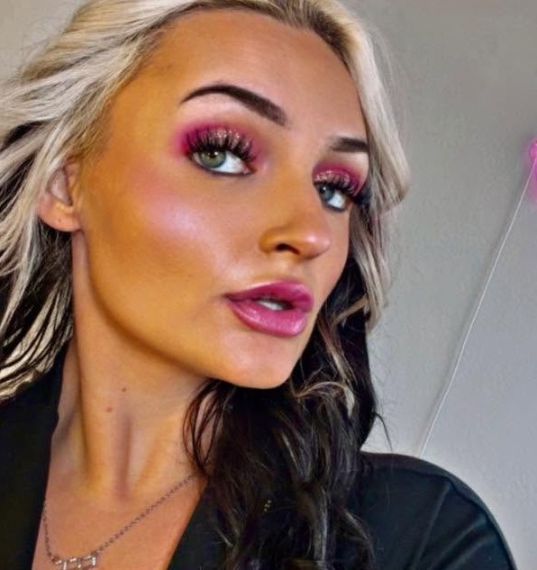 Queen K with a glowing pink crown in the background