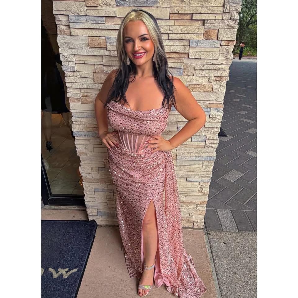 Queen K smiling in a pink sequin evening gown